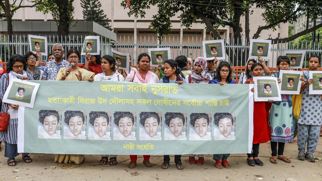 In this photo taken on April 12, 2019 Bangladeshi women hold banners and photographs of schoolgirl Nusrat Jahan Rafi at a protest in Dhaka, following her murder by being set on fire after she had reported a sexual assault. - A schoolgirl was burned t