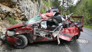 03.05.2019, Österreich, Alpbach: Ein zerstörtes Auto steht an einer Felswand. Eine Autofahrerin ist von einem herabstürzenden tonnenschweren Felsbrocken erschlagen worden. Ihre Beifahrerin überlebte nahezu unverletzt, wie die Tiroler Polizei am Freitag mitteilte. Foto: Zoom.Tirol/APA/dpa +++ dpa-Bildfunk +++