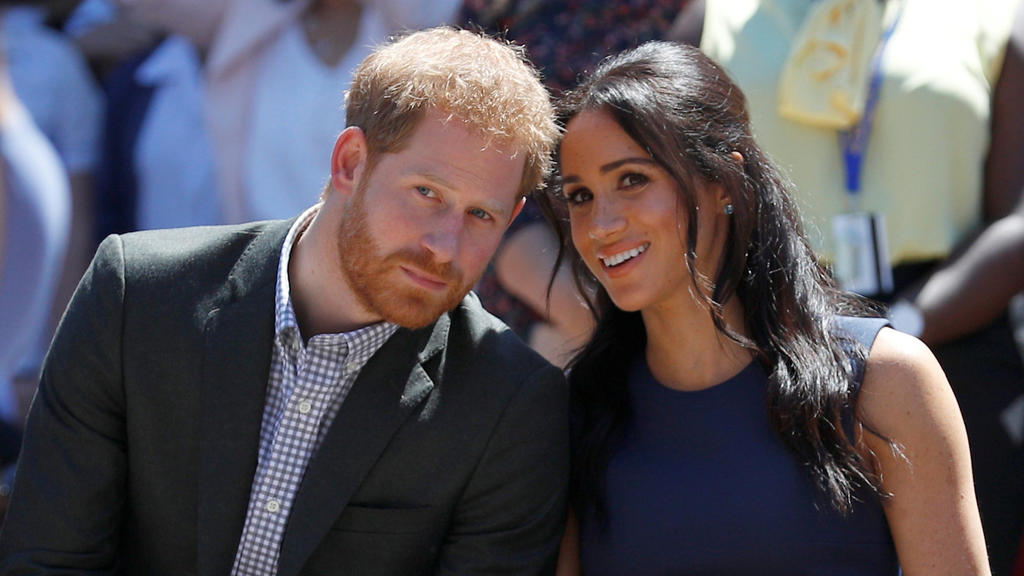 ARCHIV - 19.10.2018, Australien, Sydney: Prinz Harry von Großbritannien und seine Frau Meghan, Herzogin von Sussex, schauen sich eine Performance während ihres Besuchs an der Macarthur Girls High School an, im Rahmen ihrer ersten offiziellen gemeinsa