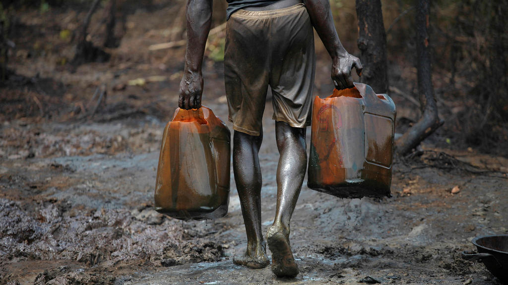 FILE PHOTO: A man works at an illegal oil refinery site near river Nun in Nigeria's oil state of Bayelsa November 27, 2012. REUTERS/Akintunde Akinleye/File Photo