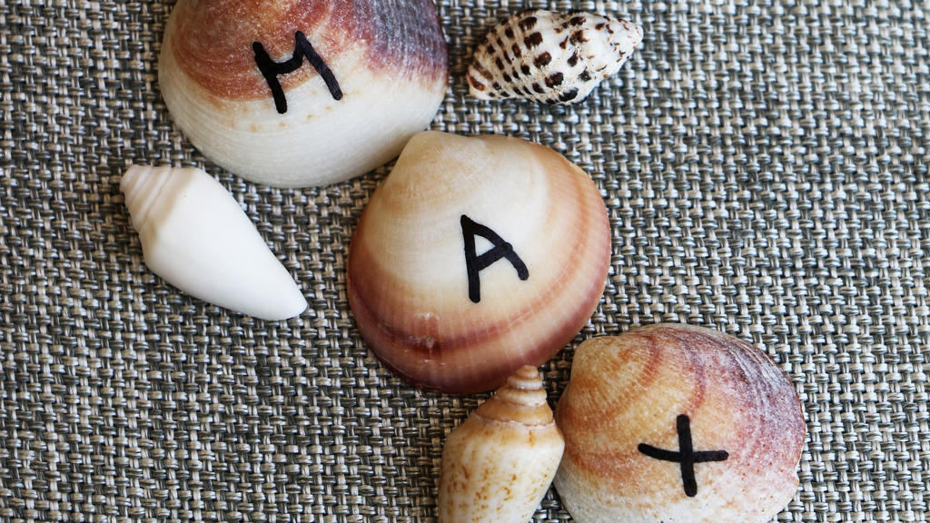 Hochzeits-DIY-Tischkarten: Namen der Gäste auf kleine Muscheln schreiben
