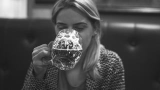 Frau trinkt Bier in einer Bar
