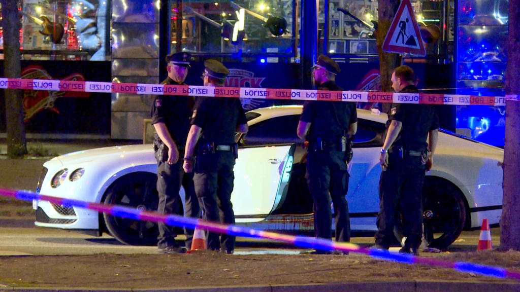 ARCHIV - 27.08.2018, Hamburg: Polizisten stehen neben einem Auto auf dem Millerntorplatz an der Reeperbahn, nachdem Schüsse gefallen waren. Am 03.06.2019 wird voraussichtlich das Urteil im Prozess um die Schüsse auf einen Rockerboss am Millerntor ver