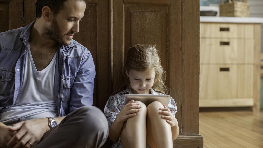 Father watching as daughter plays video game PUBLICATIONxINxGERxSUIxAUTxONLY Copyright: SigridxOlsson B61496922