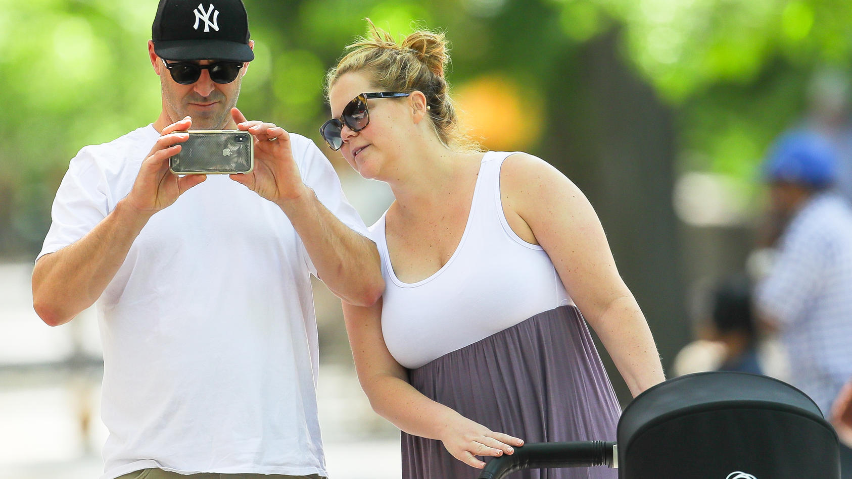 Amy Schumer and Chris Fischer were spotted showing some PDA while pushing the New Born in a stroller at a park in New York City, the new parents were spotted having fun while taking pics of the photographersPictured: Amy Schumer and Chris FischerRef: