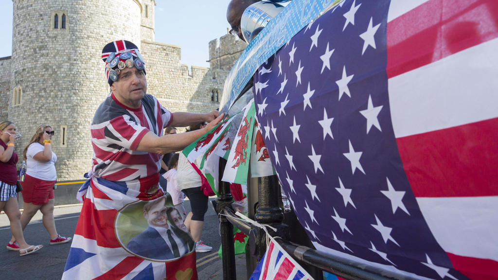 06.07.2019, Großbritannien, Windsor: John Loughrey, Fan der britischen Königsfamilie, hängt vor der Taufe des Sohne von Prinz Harry und Herzogin Meghan vor dem Schloss Windsor Nationalflaggen auf. Archie wird in Windsor bei einer Zeremonie im privat