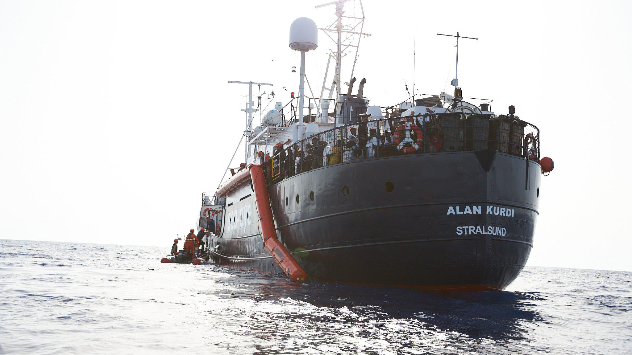 HANDOUT - 05.07.2019, ---: Flüchtlinge werden vor der Küste von Libyen von Mitgliedern der Rettungsorganisation Sea-Eye (l) auf deren Hilfsschiff "Alan Kurdi" gebracht. Foto: Fabian Heinz/Sea-Eye/dpa - ACHTUNG: Nur zur redaktionellen Verwendung im Zu