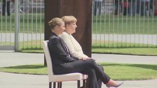 Bundeskanzlerin Angela Merkel hört die Nationalhymne im Sitzen