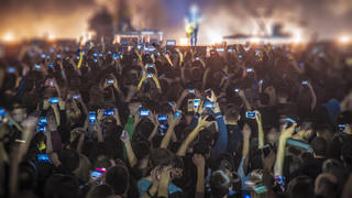 Viele Besucher filmen ein Konzert mit dem Handy.