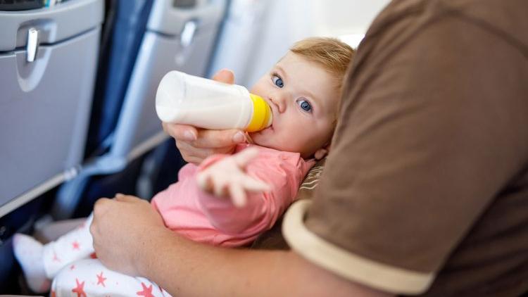 Baby isst seinen Babybrei im Flugzeug