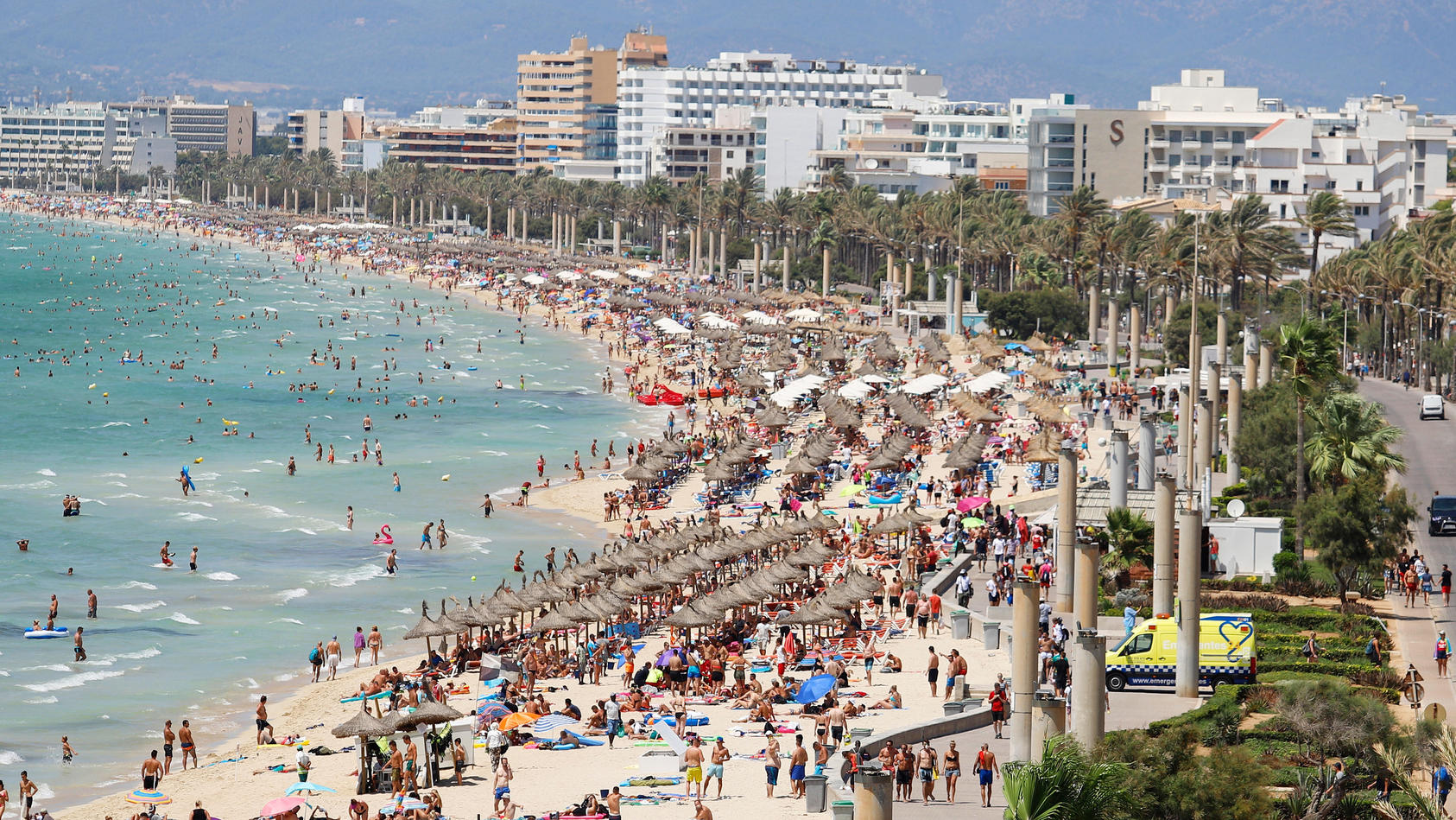 ARCHIV - 12.08.2018, Spanien, Palma: Hotels stehen am Strand von El Arenal, an dem zahlreiche Touristen die Sonne genießen. Mit Schnäppchenpreisen und Rabatten von bis zu 50 Prozent werben Veranstalter um Kurzentschlossene. (zu dpa: "Gute Zeiten für 