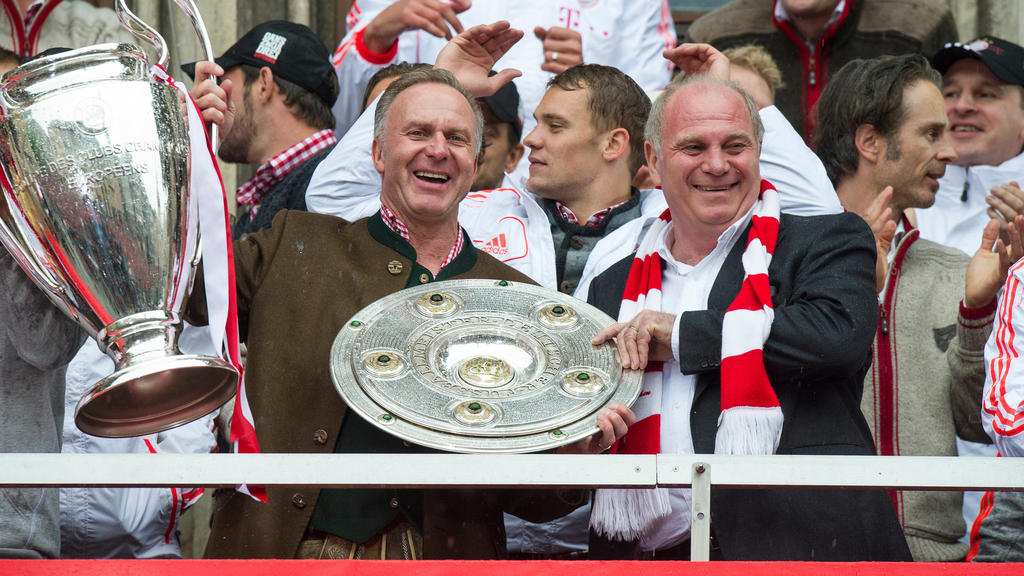 Der Vorstandsvorsitzende des FC Bayern München, Karl-Heinz Rummenige (l) und der Präsident des FC Bayern München, Uli Hoeneß, feiern am 02.06.2013 in München (Bayern) auf dem Balkon des Rathauses am Marienplatz nach dem Sieg im DFB-Pokal-Finale gegen