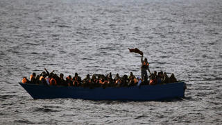 ARCHIV - 03.02.2017, ---: Flüchtlinge aus Afrika rufen auf dem Mittelmeer in einem Boot um Hilfe. (ILLUSTRATION zu dpa "115 Migranten nach Bootsunglück im Mittelmeer vermisst") Foto: Emilio Morenatti/AP/dpa +++ dpa-Bildfunk +++