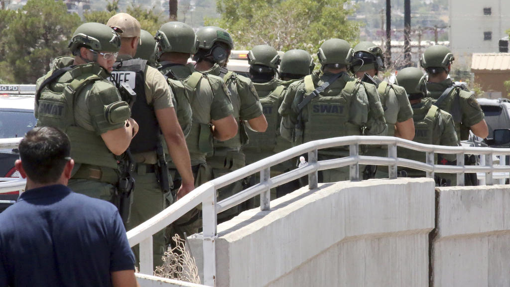 03.08.2019, USA, El Paso: Mitglieder einer Spezialeinheit der Polizei warten in der Nähe eines Ladenkomplexes, in dem ein Mann zahlreiche Menschen erschossen hat. Die Hintergründe der Tat blieben zunächst unklar. Foto: Mark Lambie/The El Paso Times/A