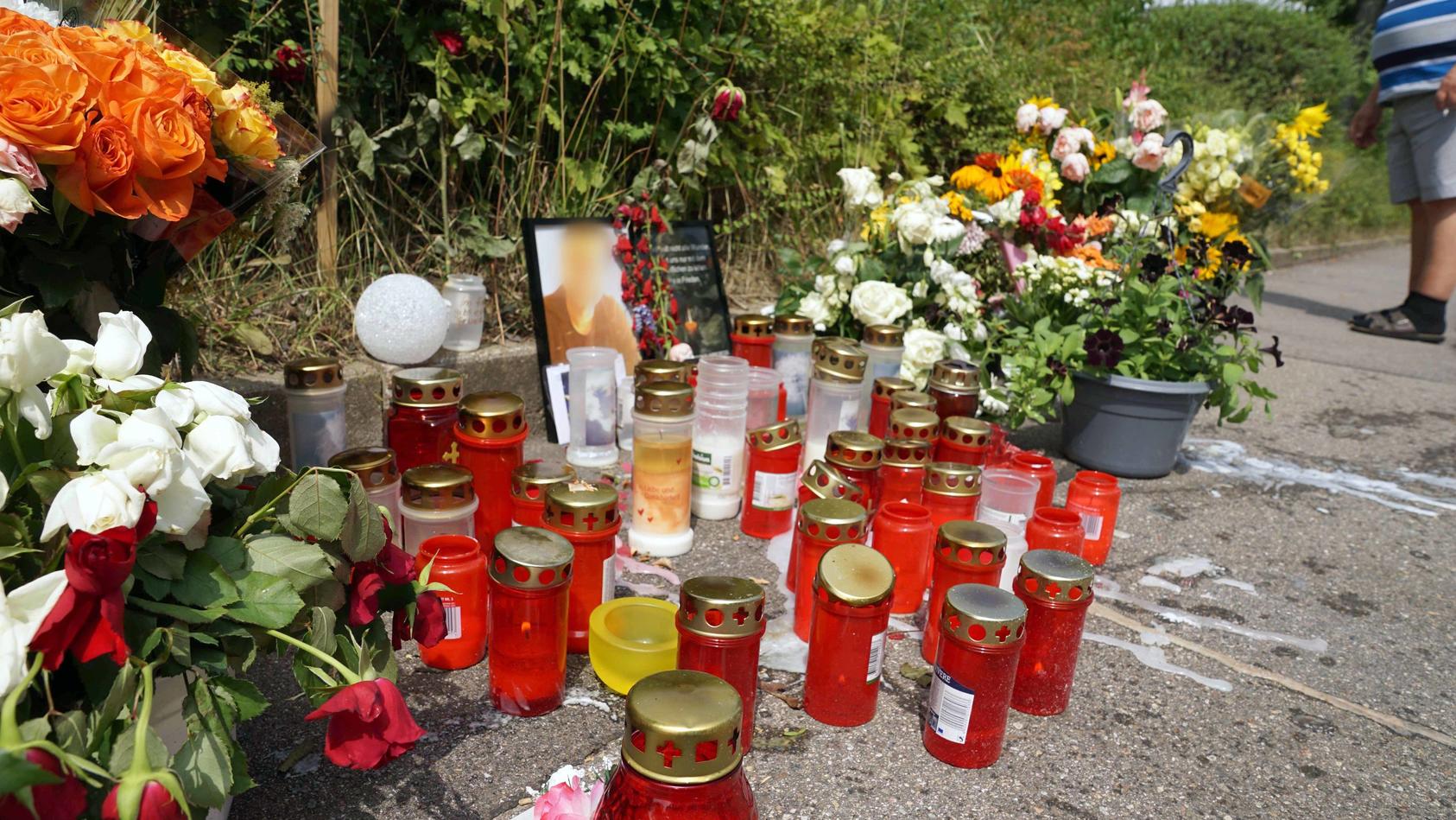 05.08.2019, Baden-Württemberg, Stuttgart: Kerzen und Blumen stehen am Tatort um ein Porträt des dort getöteten Mannes herum. Die Bestürzung ist auch Tage nach dem Schwert-Angriff in Stuttgart weiterhin groß. Der inzwischen in Untersuchungshaft sitzen