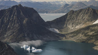 14.08.2019, Grönland, Kulusuk: Eisberge treiben zwischen schneefreien Bergen nahe Kulusuk auf dem Wasser. Das Bild wurde aus einem Flugzeug mit Nasa-Wissenschaftlern heraus aufgenommen. Die Wissenschaftler untersuchen das fortschreitende Abschmelzen des ewigen Eises in Grönland. Foto: Mstyslav Chernov/AP/dpa +++ dpa-Bildfunk +++