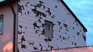 Beschädigte Verkleidung einer Hauswand