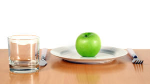 Gedeckter Tisch mit einem Apfel auf dem Teller.