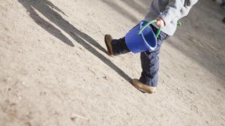 Little boy walking with sand bucket PUBLICATIONxINxGERxSUIxAUTxONLY Copyright: SandroxDixCarloxDarsa B29026317  