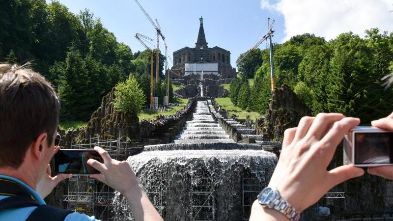 Touristen fotografieren Wasserspiele im Kasseler Bergpark