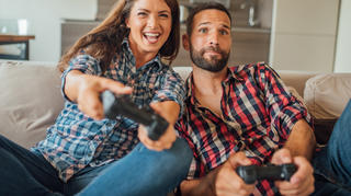 Frau und Mann spielen Playstation