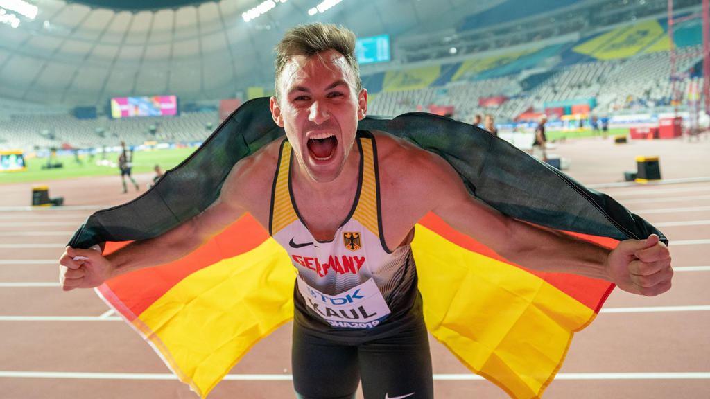 Zehnkämpfer Niklas Kaul posiert bei der Leichtathletik-WM in Katar mit Deutschland-Flagge