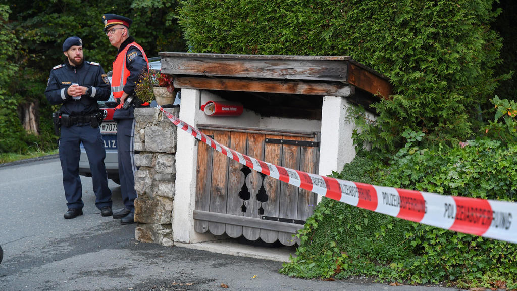 06.10.2019, Österreich, Kitzbühel: Zwei Polizisten stehen neben einer Absperrung. Die Polizei in Österreich ermittelt wegen eines Tötungsdelikts mit fünf Opfern. Foto: Zoom.Tirol/APA/dpa +++ dpa-Bildfunk +++