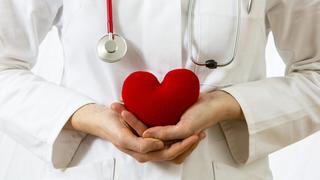 Medizinerin hält ein rotes Herz in den Händen, Symbolbild Herzinfarkt | Verwendung weltweit, Keine Weitergabe an Wiederverkäufer.