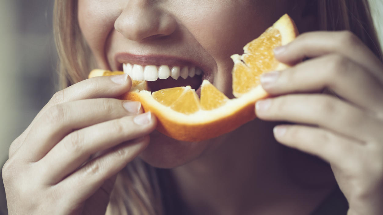 Frau isst Orange