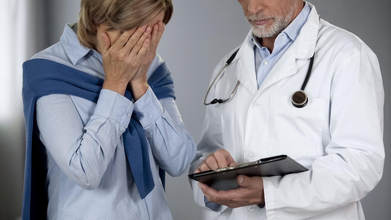 Ältere Frau weint vor Arzt im Krankenhaus