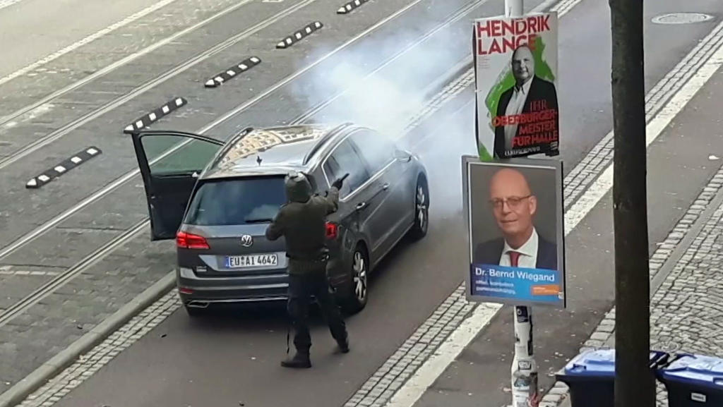 09.10.2019, Sachsen-Anhalt, Halle: In dem Videostandbild steht ein Mann hinter einem Auto und schießt mit einer Waffe auf der Straße. Ein schwerbewaffneter mutmaßlicher Rechtsextremist hatte am Mittwoch versucht, in die Synagoge einzudringen und dort