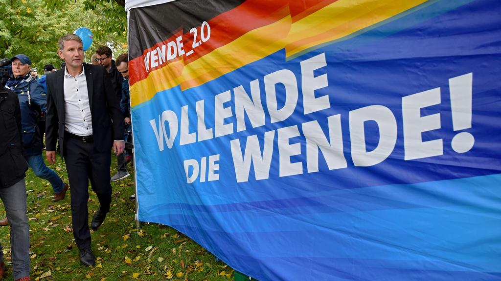 03.10.2019, Thüringen, Mödlareuth/Töpen: Der Spitzenkandidat der AFD-Thüringen Björn Höcke geht an einem Banner mit der Aufschrift "Wende 2.0. Vollende die Wende!" vorbei. Am Tag der Deutschen Einheit hat die AFD bei einer Kundgebung im ehemals getei
