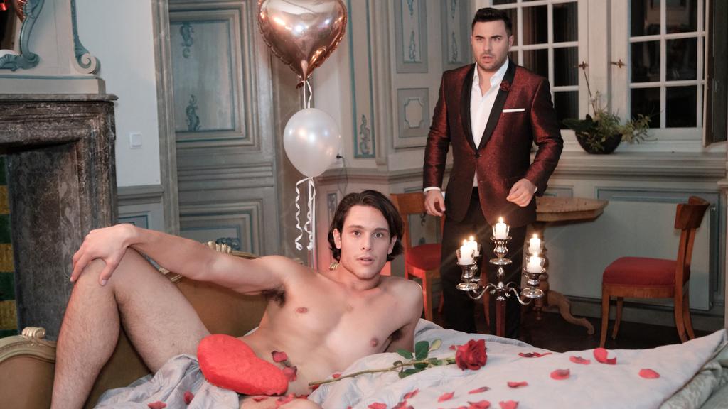In der romantisch geschmückten Hochzeitssuite liegt ein (fremder) nackter Mann (Jacopo Garfagnoli) auf ihrem Bett - Easy (Lars Steinhöfel, r.) glaubt seinen Augen nicht zu trauen. Und der ungebetene, aber sehr attraktive Gast spricht nur italienisch!