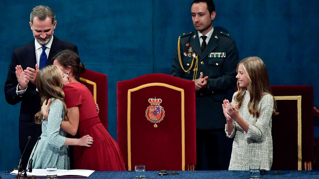 18.10.2019, Spanien, Oviedo: Die spanische Kronprinzessin Leonor (2.l), wird von ihrer Mutter spanische Königin Letizia neben dem spanischen König Felipe VI. und ihrer Schwester Sofia beglückwünscht, nachdem sie ihre erste Rede als Prinzessin von Ast
