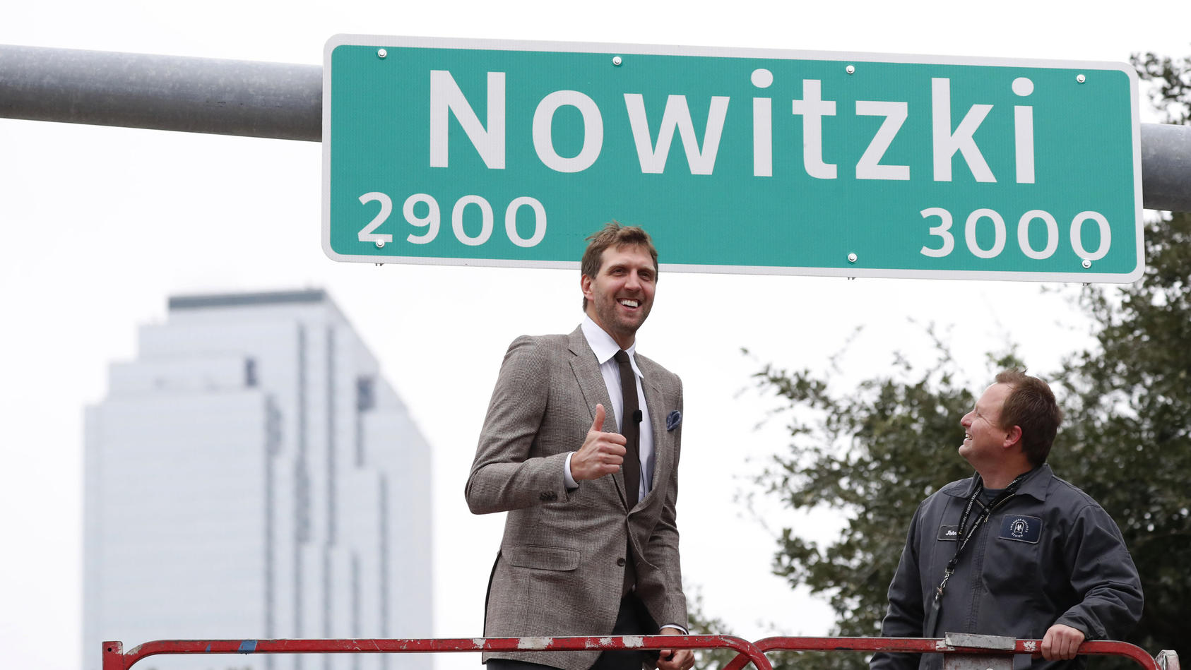 30.10.2019, USA, Dallas: Dirk Nowitzki (l) aus Deutschland, ehemaliger NBA-Basketballspieler für die Dallas Mavericks, gibt einen Daumen nach oben nach der Enthüllung eines Schilds für eine nach ihm benannte Straße. Foto: Lm Otero/AP/dpa +++ dpa-Bild