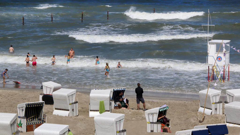 11.08.2018, Niedersachsen, Wangerooge: Badende stehen in den Wellen am Strand der Nordseeinsel. (zu dpa "Super-Sommer beschert Nordwesten großen Touristen-Ansturm" vom 11.08.2018) Foto: Peter Kuchenbuch-Hanken/dpa