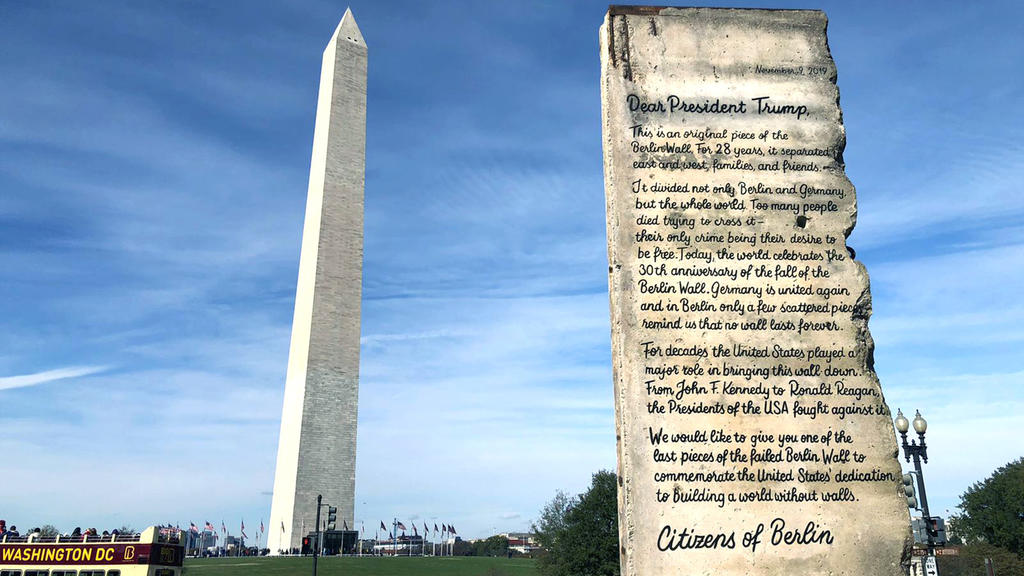 HANDOUT - 09.11.2019, USA, Washington: Ein Segment der Berliner Mauer mit einem Text an US-Präsident Trump steht vor dem Obelisken. Zum 30. Jahrestag des Mauerfalls wurde das 2,7 Tonnen schwere Originalsegment vor das Weiße Haus gekarrt, wo es abgege