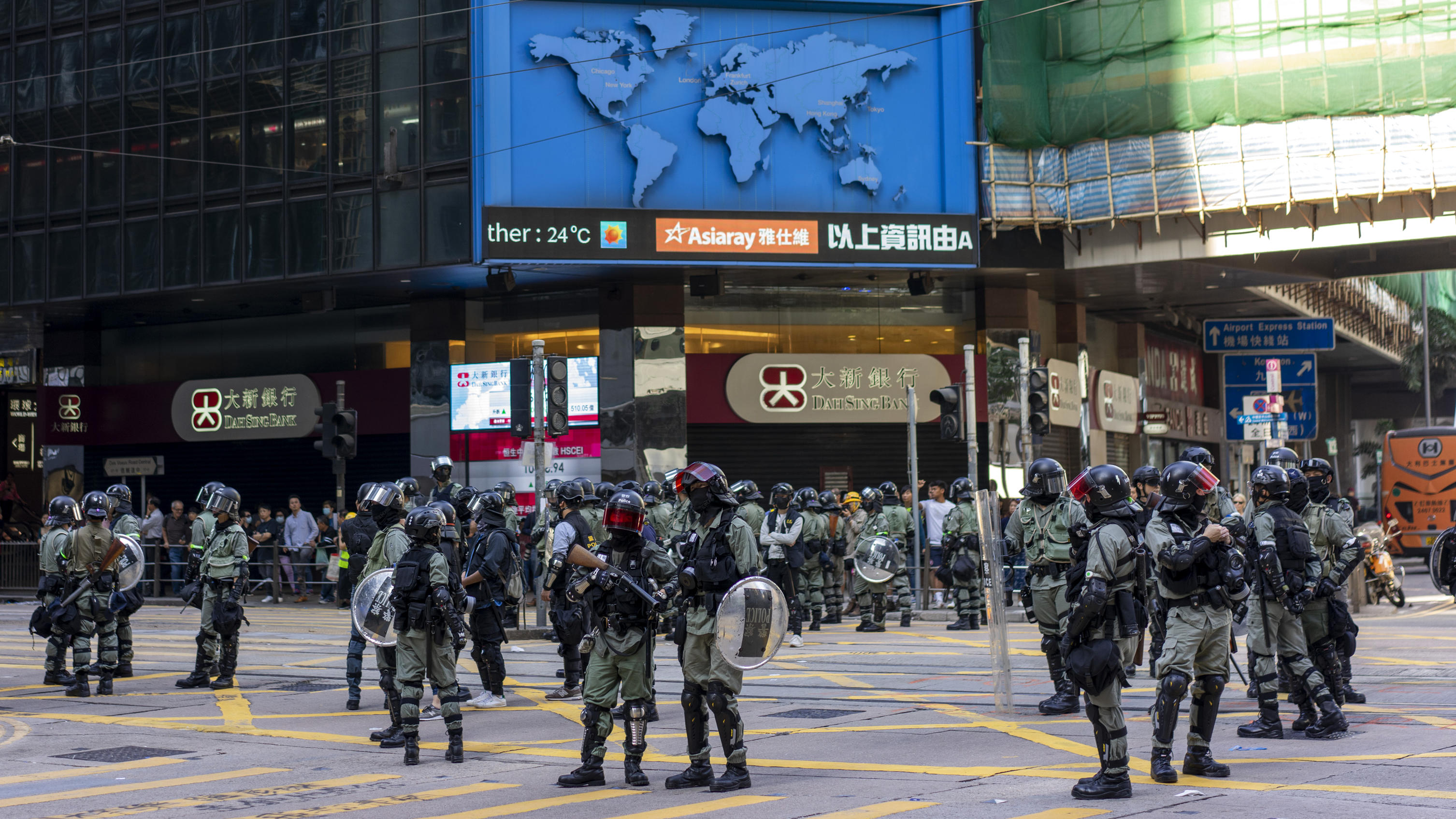  Hongkong - Hongkong - 15.11.2019 / Hong Kong Island - Central - Proteste in Hongkong 2019 / Proteste gegen Polizeigewalt - das große Aufräumen unter der Aufsicht der Polizei / Polizei mit Schild und Tränengas und Kampfausrüstung stehen am Zebrastrei