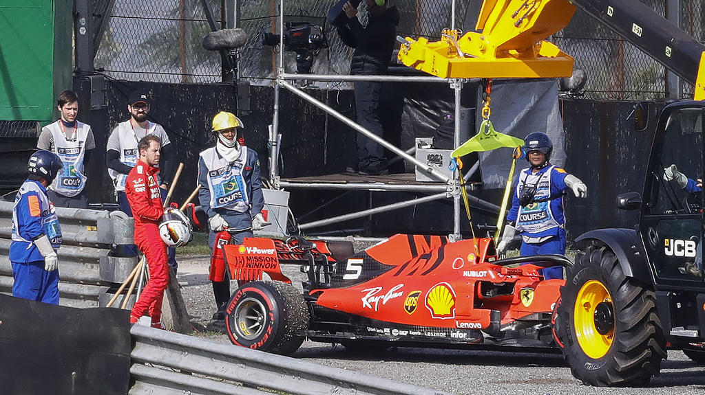 17.11.2019, Brasilien, Sao Paulo: Motorsport: Formel-1-Weltmeisterschaft, Grand Prix von Brasilien, Rennen: Sebastian Vettel (4.v.l) aus Deutschland vom Team Ferrari steht neben seinem Rennenwagen nach einem Unfall mit seinem Teamkollegen Leclerc. In