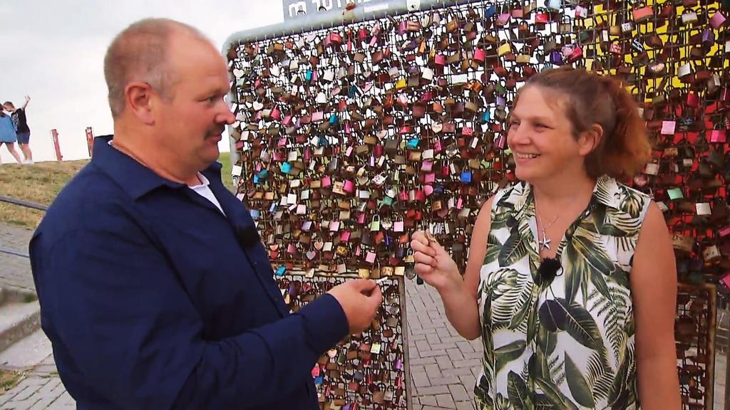Bauer Burkhard und seine Tanja hängen ein Liebesschloss auf.