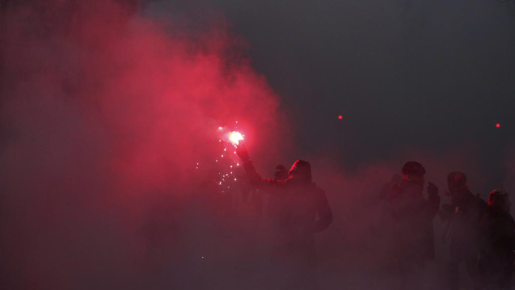 Frankreich, Paris: Ein Demonstrant hält ein bengalisches Feuer. Bei den Demonstrationen gegen die geplante Rentenreform in Frankreich ist es zu Ausschreitungen gekommen.