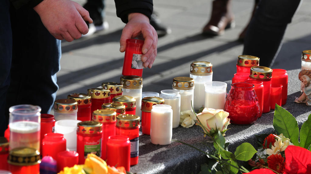 09.12.2019, Bayern, Augsburg: Ein Mann plaziert ein Grablicht an einem Rondell am Königsplatz. Ein Feuerwehrmann war am Freitagabend (06.12.2019) hier in seiner Freizeit nach einem Schlag so schwer verletzt worden, dass er noch vor Ort starb. Foto: K