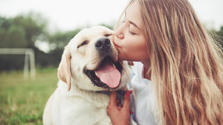 Frau küsst ihren Hund