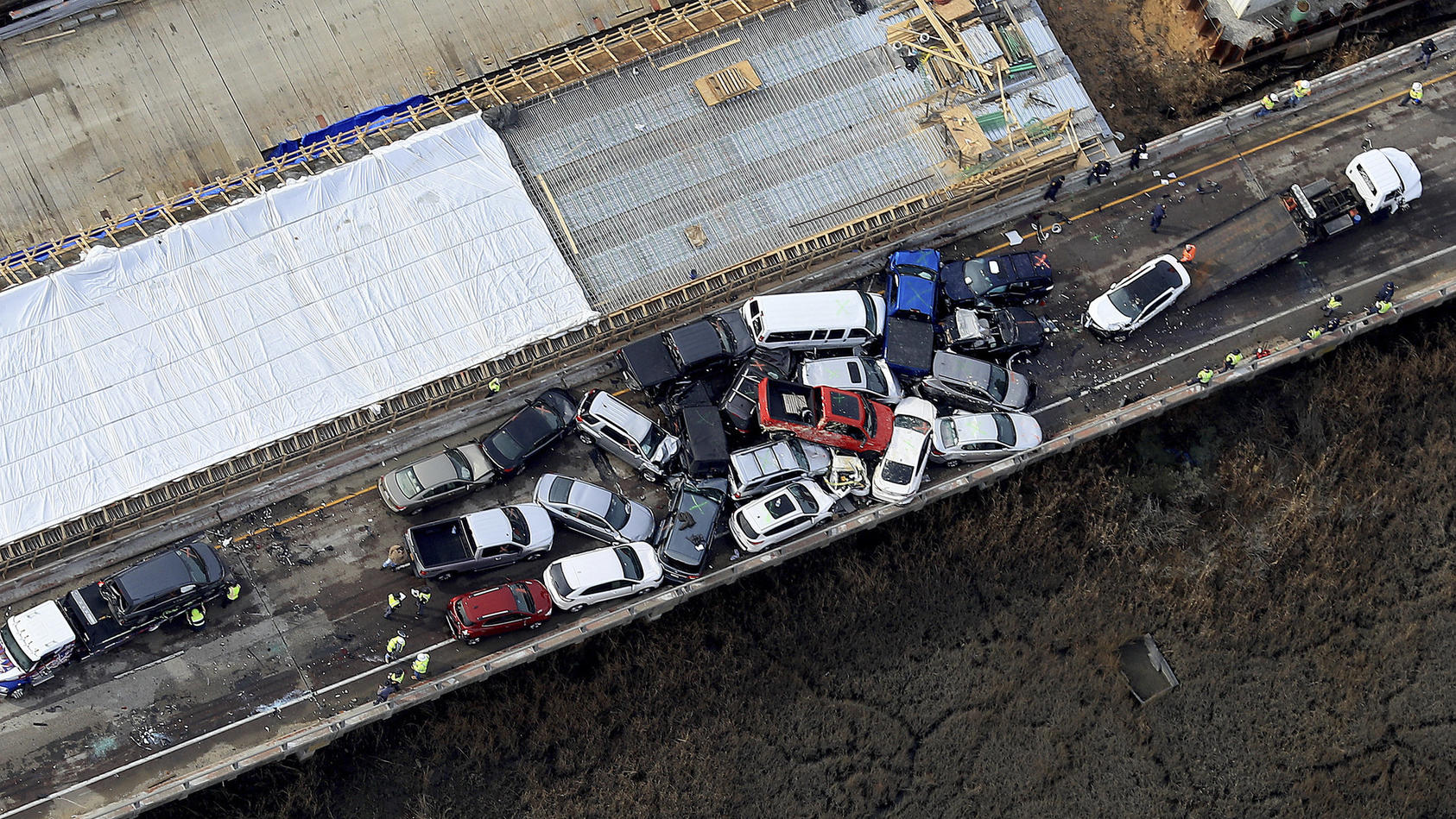 22.12.2019, USA, York County: Bergungsarbeiter räumen einen Unfallort. Auf der Queens Creek Überführung auf der I-64 in York County ist es zu einer Massenkarambolage mit mehreren Fahrzeugen gekommen. Foto: Rob Ostermaier/The Daily Press/AP/dpa - ACHT