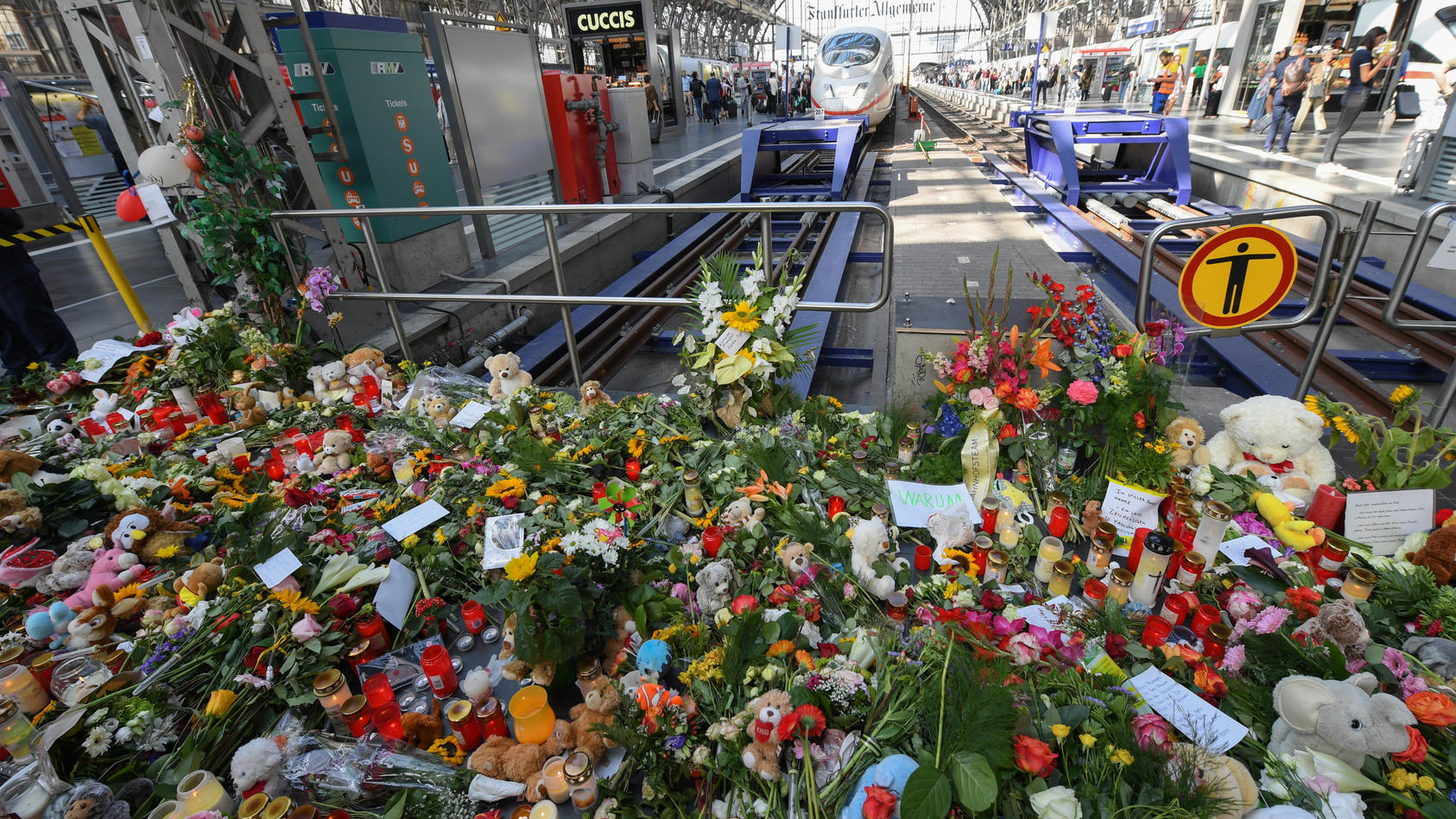ARCHIV - 31.07.2019, Hessen, Frankfurt/Main: Ein Meer aus Blumen, Kuscheltieren und Beileidsbekundungen hat sich am Gleis 7 des Hauptbahnhofs gebildet. Ein achtjähriger Junge wurde hier am 29. Juli von einem Mann vor einen einfahrenden ICE gestoßen u