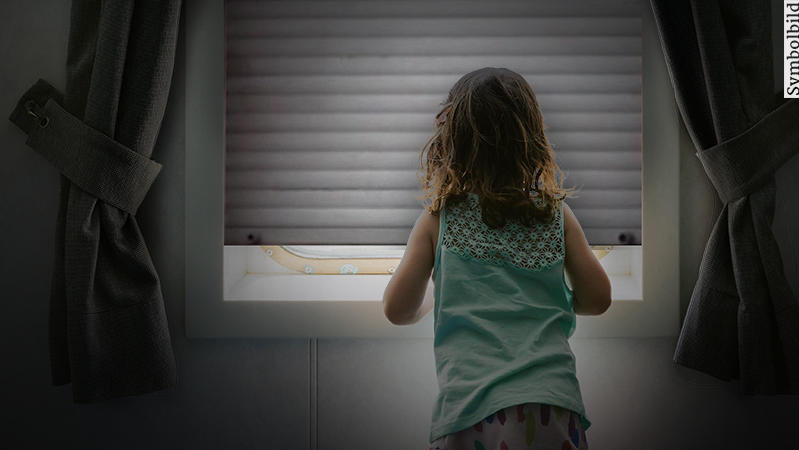 Mädchen vor geschlossenem Fenster (Symbolbild).