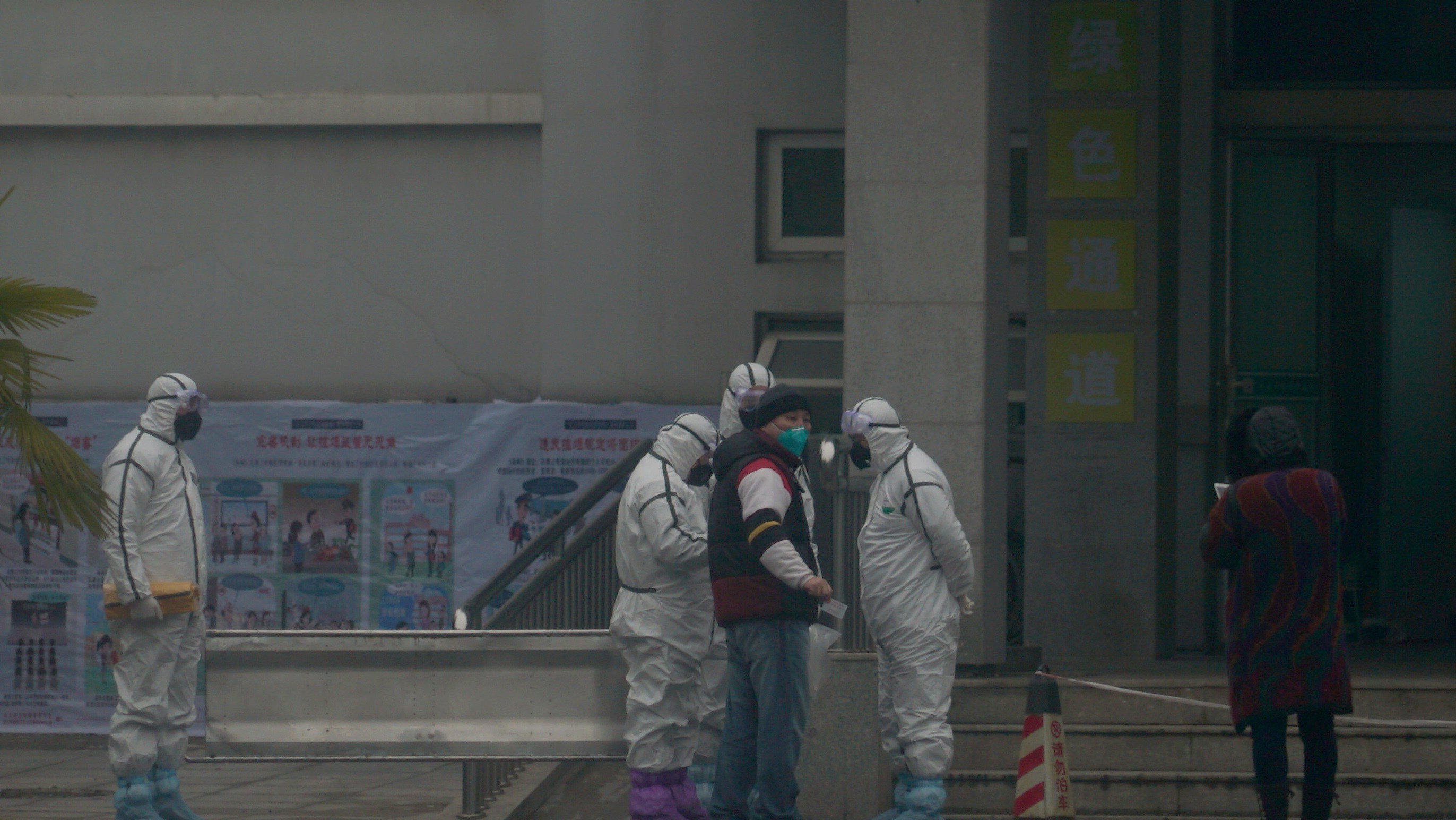 21.01.2020, China, Wuhan: Mitarbeiter in Schutzanzügen stehen vor dem Wuhan Medical Treatment Center, in dem ein Patient mit Verdacht auf den neuartigen Corona-Virus behandelt wurde. Foto: Dake Kang/AP/dpa +++ dpa-Bildfunk +++