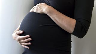 31.07.2018, Finnland, Helsinki: Eine schwangere Frau hält sich den Bauch. Foto: Emmi Korhonen/Lehtikuva/dpa +++ dpa-Bildfunk +++