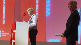 27.01.2020, Berlin, Berliln: Eine junge Klimaaktivistin steht beim Jahresempfang des Bundesverbands mittelständische Wirtschaft neben Joe Kaeser, Vorstandsvorsitzender von Siemens, auf der Bühne. Sie hatte sich grüne Farbe auf die Wange gestrichen, stürmte vor dem Auftritt von Kaeser auf die Bühne und hielt eine kurze Rede. (bestmögliche Qualität) Foto: Andreas Hoenig/dpa +++ dpa-Bildfunk +++