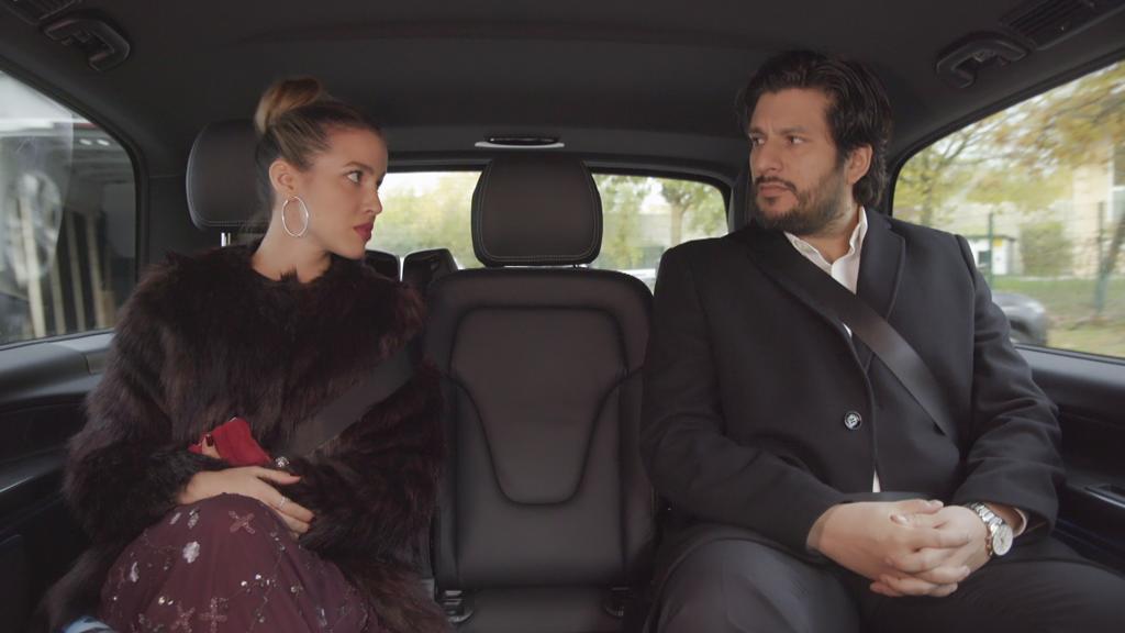 AWZ: Chiara und Maximilian sitzen nebeneinander im Auto und schauen sich an.